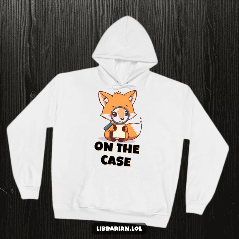 Funny hoodie featuring a fox with a magnifying glass investigating a scattered note, perfect for cozy mystery buffs.