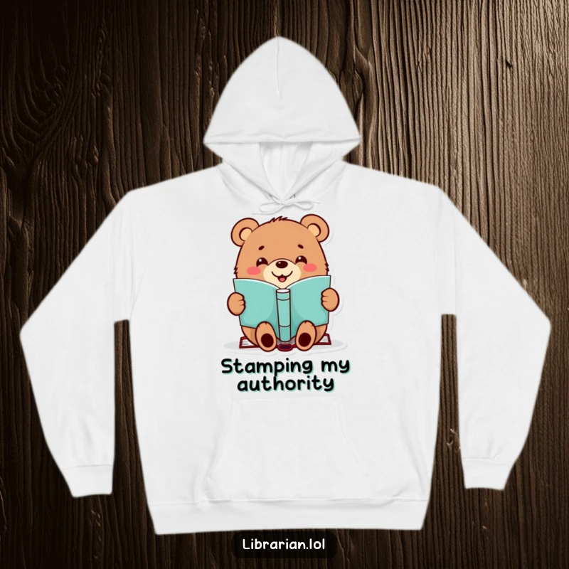 Funny hoodie featuring a cheerful bear happily stamping a book, perfect for cozy reading sessions.